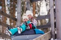 Joyful girls ride a tubing from a hill together. Winter holiday