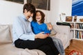 Joyful grandmother and grandson playing games on smartphone together at home