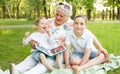 Joyful grandmother spending time with his grandsons in the park