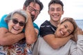 Joyful group of mothers and sons, several generations of the same family, have fun outdoors by the sea. From teenager to grandma