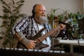 Joyful guitarist with overweight plays music recording new song in home studio Royalty Free Stock Photo