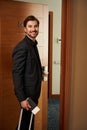 Joyful guy opens a door of hotel room Royalty Free Stock Photo