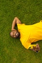 Joyful handsome african american male laying on the grass, relaxing and taking a break after workout. Smiling happy man Royalty Free Stock Photo