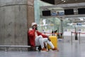 Joyful handsome black male wearing red jacket smiling making mobile phone call while waiting flight Royalty Free Stock Photo