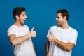 Joyful handsome guys screaming and showing thumbs up