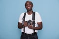 Joyful handsome looking african ethnicity guy with photo device posing with confidence. Royalty Free Stock Photo