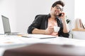 Joyful handsome man in eyeglasses talking by smartphone