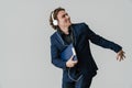 Joyful handsome man in headphones dancing with folder