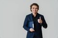 Joyful handsome man showing thumb up while posing with folder