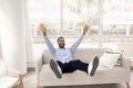 Joyful happy African man sitting on comfortable couch at home Royalty Free Stock Photo