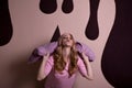 Joyful happy blonde girl playing with pillows on a pink studio b Royalty Free Stock Photo