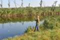 A joyful and happy boy rejoices at his first catch of fish on a fishing rod on the river