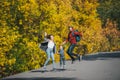 Joyful happy family jump on country road in autumn. Parents and kid on countryside background