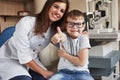 Joyful and happy. Female eye doctor sitting with the kid after doing the vision test Royalty Free Stock Photo