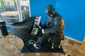 Joyful, happy inspired black musician sculpture playing piano