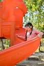 Joyful and happy little Asian girl playing on slider, enjoying outdoor activity Royalty Free Stock Photo
