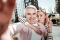 Joyful happy man taking a selfie with his wife