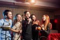 Joyful happy young people have party in karaoke bar Royalty Free Stock Photo