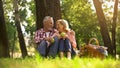 Joyful healthy old couple relaxing on grass, holding apples and hugging, picnic Royalty Free Stock Photo