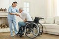Joyful helpful caregiver holding her patients hand