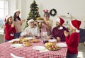 Joyful hostess grandmother bringing out turkey during Christmas meal with family. Royalty Free Stock Photo