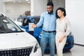 Joyful Husband Showing New Car To Wife In Dealership Store Royalty Free Stock Photo