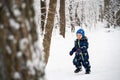 A joyful and independent kid walks through the winter forest Royalty Free Stock Photo