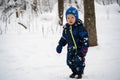 A joyful and independent kid walks through the winter forest Royalty Free Stock Photo