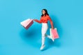 Joyful Indian Woman Holding Shopper Bags Jumping On Blue Background