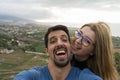 Joyful interracial Heterosexual Couple, Husband and Wife take a selfie looking at camera with affection, outside in honeymoon trip Royalty Free Stock Photo