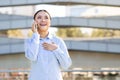 Joyful Japanese businesswoman smiling chatting on her phone, standing outside Royalty Free Stock Photo