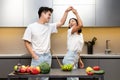 Joyful Japanese Couple Dancing And Laughing In Modern Kitchen Royalty Free Stock Photo