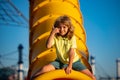 Joyful kid boy having fun on playground outdoors. Thumbs up. Happy blond kid boy having fun and sliding on outdoor Royalty Free Stock Photo