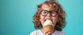 Joyful Kid Delighting In Ice Cream Cone Against A Vibrant Blue Backdrop