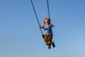 Joyful kid swinging on a swing. Happiness children. Child extreme swinging. Danger high Swing in sky. Craziness and