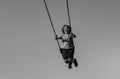 Joyful kid swinging on a swing. Happiness children. Child extreme swinging. Danger high Swing in sky. Craziness and