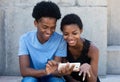 Joyful laughing african american couple looking at phone Royalty Free Stock Photo