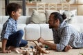 Joyful African American kid boy playing toys with father. Royalty Free Stock Photo