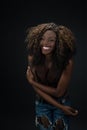 Joyful laughing African American woman against a dark background