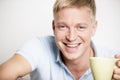 Joyful laughing young man enjoying a cup of coffee. Royalty Free Stock Photo