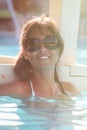 Joyful and leisure. Smiling woman with sunglasses on vacation at the pool Royalty Free Stock Photo