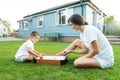 Joyful little boy and his young mother are playing portable air hockey in the garden. Fun Playing Games in Backyard Lawn Royalty Free Stock Photo