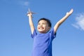 Joyful little boy holding a toy with blue sky