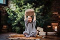 Joyful little girl with blonde curly hair wearing a warm sweater throws up a gift box while sitting on a floor next to Royalty Free Stock Photo