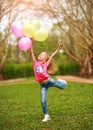 Joyful little girl child jumping from happiness in spring green park