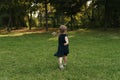 Joyful little girl running on green grass