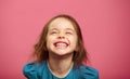 Joyful little girl sincere laughing at pink isolated background.