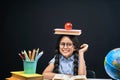 Joyful little girl sitting at the table with pencils and books textbooks. Happy child pupil doing homework at the table Royalty Free Stock Photo