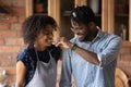 Joyful loving mixed race family couple having fun cooking meal.