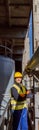 Joyful male engineer standing near metal pipe at factory Royalty Free Stock Photo